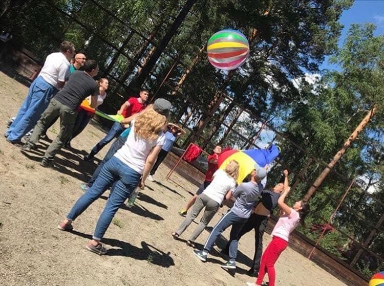 Игра с полотном и мячом на корпоративном тимбилдинге на свежем воздухе